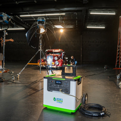 Portable power station with green and white design in a studio setting with filming equipment.